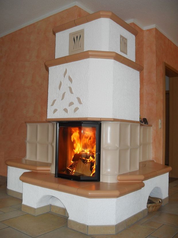 Kachelofen in Weiß und Terrakotta mit Blattmotiv und Bogenfuß