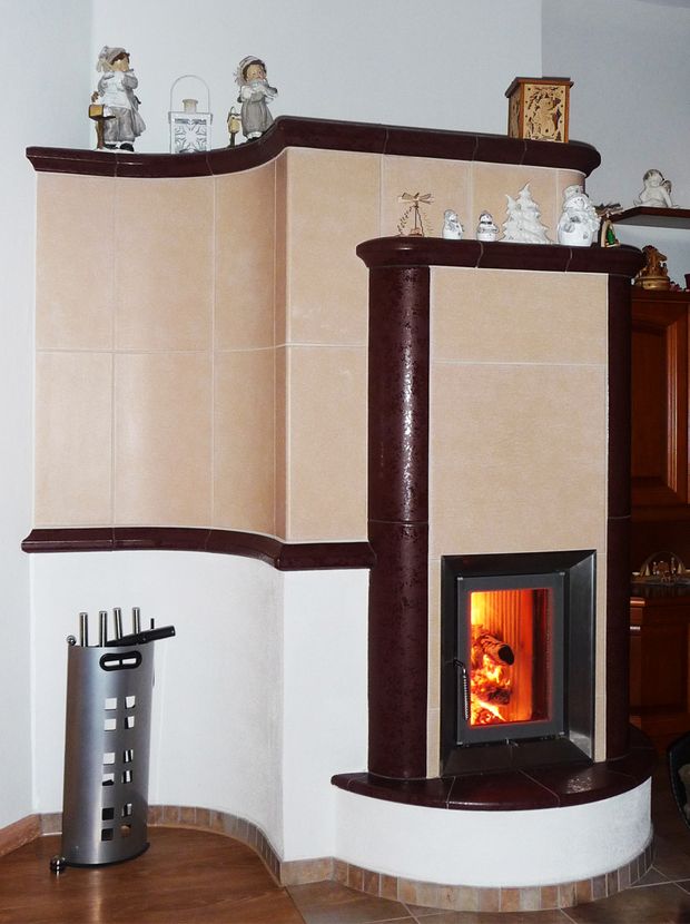 Kachelofen in Creme mit dunkelbrauner geschwungener Schmucksäule